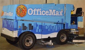 zamboni wrapped with blue Office Max ad featuring a city skyline and a really big ball of rubber bands